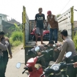Petugas sedang mengangkut puluhan sepeda motor ke atas truk untuk dibawa ke Satlantas Polres Jombang.