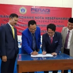 Ketua DPC Peradi Gresik Kukuh Pramono Budi, S.H., M.H. bersama Rektor Ungres Prof. Sukiyat, S.H., M.Si menandatangani MoU. foto: SYUHUD/ BANGSAONLINE