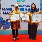Wabup Aminatun Habibah bersama Kadinkes Mukhibatul Khusnah menunjukkan 3 penghargaan yang diraih Pemkab Gresik di Hari Kesehatan Nasional (HKN) tahun 2022. Foto: Ist.