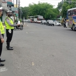 Tiga personel Satlantas Polres Madiun Kota dengan sigap menangani penumpukan kendaraan yang terjadi akibat banyaknya pemudik yang memasuki wilayah kota.