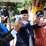 Ketua Harian Situs Ndalem Pojok Persada Sukarno, Kushartono (kiri) ketika akan melepaskan burung merpati yang membawa surat untuk Presiden Jokowi bersama peserta upacara yang lain. foto: MUJI HARJITA/ BANGSAONLINE