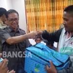 BANTUAN: Salah seorang anggota Gafatar menerima bingkisan dari Pemkab Bojonegoro. foto: eky nurhadi/ BANGSAONLINE