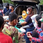 Tim RGR dibantu Kepala Kelurahan Pojok, Babinsa dan Bhabinkamtibmas Kelurahan Pojok, saat membagikan paket sembako kepada warga. foto: MUJI HARJITA/ BANGSAONLINE