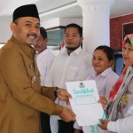 Bupati Ngawi, Ony Anwar Harsono saat menyerahkan sertifikat halal pada pelaku usaha di Pendopo Wedya Graha, Selasa (16/5/2023).