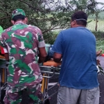 Petugas saat melakukan evakuasi kepada pengendara motor yang tewas usai menabrak pohon tumbang di Ngawi.