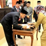 Pjs Bupati Jombang Setiajit menandatangani Raperda yang baru saja disahkan. foto: RONY S/ BANGSAONLINE