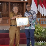 Sekda Tuban Budi Wiyana memberikan selamat kepada Senior Manajer PLN Nusantara Power UP Tanjung Awar-Awar, Yunan Kurniawan, atas diraihnya tiga penghargaan.