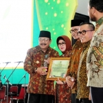 Dr. H. Soekarwo Memberikan Piagam Penghargaan Kepada Ibu Dra. Hj. Nina Soekarwo Dalam Acara Peringatan Hari Pangan Sedunia Ke 38 Di Jatim Expo Surabaya.