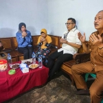 Pj Wali Kota Mojokerto Ali Kuncoro didampingi Kepala Dinsos P3A dan Kepala Diskominfo usai menyerahkan bantuan kepada salah satu lansia.