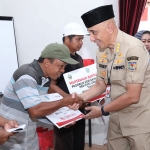 Pj Bupati Bangkalan Arief M Edie saat menyerahkan bantuan modal usaha kepada penerima.