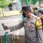 Kapolres Madiun Kota AKBP Dewa Putu Eka Darmawan sedang mengecek QR pada aplikasi PeduliLindungi.