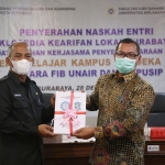 Penyerahan naskah ensiklopedia secara simbolis oleh Dekan FIB Unair, Purnawan Basundoro (kanan), kepada Kepala Dispusip Kota Surabaya, Musdiq Ali Suhudi.