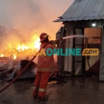 Petugas Damkar Gresik saat memadamkan kobaran api. Foto: SYUHUD/BANGSAONLINE