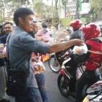 Anggota PWI dan Forwas begitu semangat saat membagikan takjil kepada pengendara motor. foto: NANANG I/ BANGSAONLINE