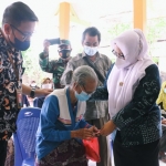 Wabup Bu Min menyerahkan bansos kepada seorang lansia. foto: SYUHUD/ BANGSAONLINE