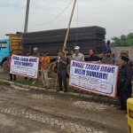 Puluhan massa LSM Mojokerto Watch saat demo di lokasi proyek pembangunan gedung barang bukti milik Kejaksaan Tinggi Provinsi Jawa Timur di Jalan Raya Jatirejo, Mojokerto, Rabu (9/11/2022).
