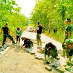 Para personel Satgas TMMD Kodim Ngawi sedang memasang paving.