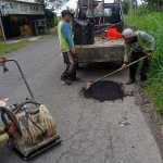 Petugas dari Dinas PUPR Jombang saat memperbaiki jalan.