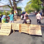 Warga Desa Gununggangsir Kecamatan Beji, Kabupaten Pasuruan saat menggelar aksi demo menutup akses jalan desa setempat, Jum’at (6/10) siang.