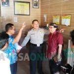 Ketua PWI Jombang, Sutono (baju merah) didampingi kuasa hukum Lilik Yulianto saat melapor ke SPKT Polres Jombang, Jumat (7/7/2017). foto: ROMZA/ BANGSAONLINE