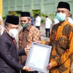 Wakil Wali Kota Batu Punjul Santoso saat menyerahkan sertifikat arah kiblat kepada salah satu takmir masjid.