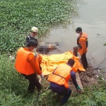 Petugas saat mengevakuasi mayat yang ditemukan di pinggir Sungai Brantas.