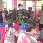 Kapolsek Krembung saat mendampingi Bupati Sidoarjo meninjau pelaksanaan vaksinasi Covid-19 warga Pura Agung Margo Wening.