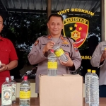 Petugas Unit Reskrim Polsek Pagu saat menunjukkan barang bukti puluhan botol minuman keras. Foto: Ist.