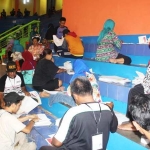 KPU Kabupaten Pasuruan melibatkan sejumlah warga untuk melipat kertas suara Pemilu. foto: AHMAD HABIBI/ BANGSAONLINE