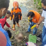 Petugas saat mengevakuasi mayat balita yang ditemukan di bantaran sungai.