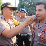 Wakapolres Kediri Kompol Andik Gunawan saat mencukur kumis salah satu anggota.