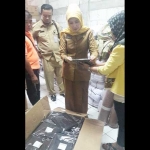 Nur Maslicah, Kabid Dikmen Dispendik Gresik, saat mengecek kain seragam gratis. foto: SYUHUD/ BANGSAONLINE