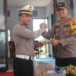 Kapolres Ngawi AKBP. MB. Pranatal Hutajulu menyerahkan potongan tumpeng tanda peresmian Pos Laka 3 Jalur Tol Ngawi.