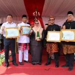 Wabup Gresik, Aminatun Habibah dan Kadisnaker Andhy Hendro Wijaya serta perwakilan perusahaan usai menunjukkan penghargaan K3. Foto: SYUHUD/BANGSAONLINE.com