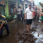 Warga dibantu aparat dan relawan membersihkan lumpur dan material yang terbawa saat banjir bandang. foto: ist.