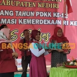 Ketua PDKK, Umi Salamah, saat menerima potongan tumpeng dari Kepala Dinsos Kabupaten Kediri, Dyah Saktiana (dua dari kanan). Foto: MUJI HARJITA/ BANGSAONLINE