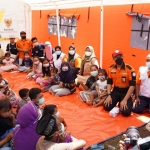 Presiden Joko Widodo (Jokowi) saat menyapa anak-anak yang mendapat pelayanan psikososial di tenda Ruang Ramah Anak Milik Baznas Jawa Timur.