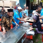 IKUT JUALAN: Bupati Saiful Ilah didampingi Plt Kadis Perikanan HM Bachruni Aryawan melayani pembeli bandeng murah, Kamis (7/11). foto: MUSTAIN/ BANGSAONLINE