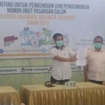 Nur Syamsi, Ketua KPU Kota Surabaya didampingi Soeprayitno, Divisi Teknis Penyelenggaraan menunjukkan surat penetapan paslon. 