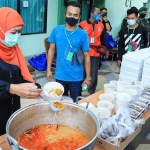 Gubernur Khofifah melayani para pekerja migran yang hendak menikmati ketupat sayur.