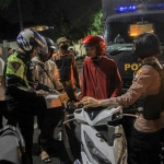 Petugas Satlantas Polrestabes Surabaya saat melakukan pemeriksaan terhadap pengendara bermotor. 