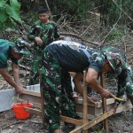 Satgas TMMD ke-115 saat membuat gapura di Desa Kramat, Pulau Mengare, Kecamatan Bungah, Kabupaten Gresik.