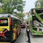 Petugas kepolisian saat mengatur lalu lintas usai kecelakaan yang melibatkan Bus dan Fuso di Jalan Raya Branta Tinggi, Pamekasan.