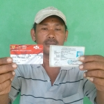 Samsul Aripin menunjukkan Kartu Keluarga Sejahtera (KKS) miliknya.