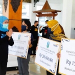 Gubernur Jawa Timur Khofifah Indar Parawansa menyerahkan bantuan  saat kunjungan kerja di Kabupaten Pacitan, Minggu (18/10). foto: ist/ bangsaonline.com