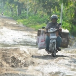 LICIN DAN BECEK: Salah seorang pengendara motor sedang melintas dengan hati-hati. Foto: EKY NUR HADI/ BANGSAONLINE