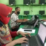 Wahyu Widyaningsih, Kepala SMPN 2 Papar saat memonitor kegiatan belajar dari rumah peserta didik melalui komputer di sekolah.