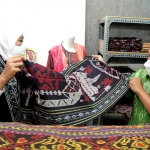 Khofifah dalam sebuah kesempatan meninjau stan yang menjual kain tenun dalam sebuah pameran.