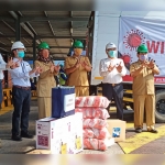 Direktur PT. Wilmar Group Soronto menyerahkan simbolis bantuan kepada lurah dan kades sekitar perusahaan. foto: SYUHUD/ BANGSAONLINE