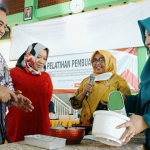 General Manager of CSR SIG Edy Saraya (kiri) melihat praktik pelatihan pembuatan kue di Desa Sidorukun, Kecamatan Gresik. foto: ist.